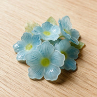 Close-up of handmade blue forget-me-not flowers inside a pet memorial shadow box